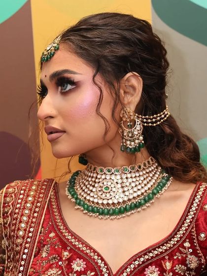 A close-up of a model wearing a beautiful Kundan choker with green beads. The side view shows the matching earrings and sahara chain.