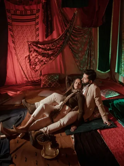An intimate moment from one of our stylized indoor shoots, using warm lighting and rich textiles to create a cozy, romantic ambiance. This demonstrates our versatility in crafting beautiful narratives within a controlled studio environment.
