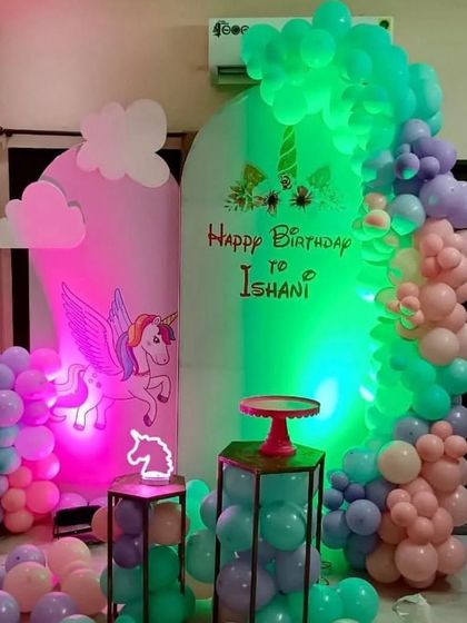 A magical unicorn-themed party with a winged unicorn cutout, pastel balloons, and colorful lighting effects.