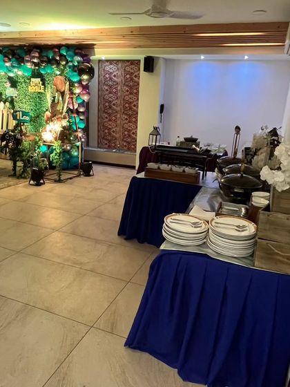 The overall catering setup for an indoor 'Fortnite' themed birthday party. The blue table skirting and organized buffet line create a clean and professional look.