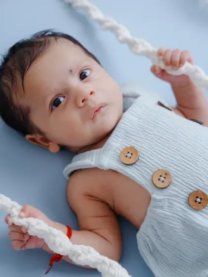 This alert newborn is enjoying his time on the cloud-themed swing, looking right at the camera with his big, beautiful eyes.