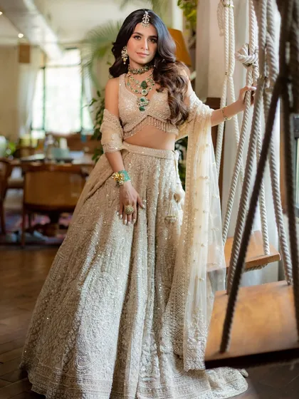 The gentle movement in this photo shows the flow of the ivory lehenga, proving that a grand outfit can also feel light and comfortable.