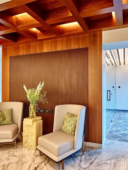 We create casual seating areas even within formal spaces. This nook, with its comfortable armchairs and onyx side table, offers a place to relax against a backdrop of rich wood paneling and a coffered ceiling.