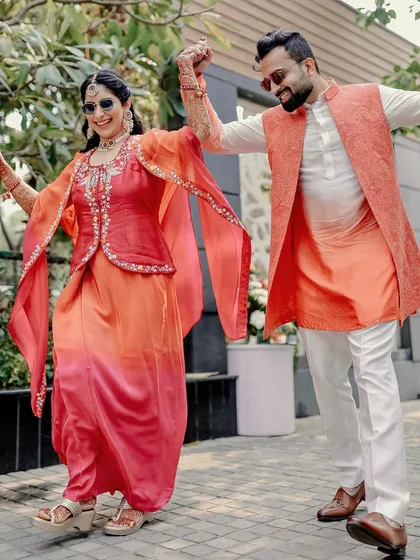 A happy and energetic portrait of the couple dancing, their colorful outfits perfect for the festive occasion.