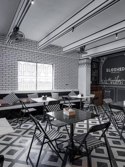 The finished 'Sloshed' sketch cafe, a space where we played with perception by creating a monochromatic, ink-line world. The design is a conversation starter and a truly unique backdrop for dining.