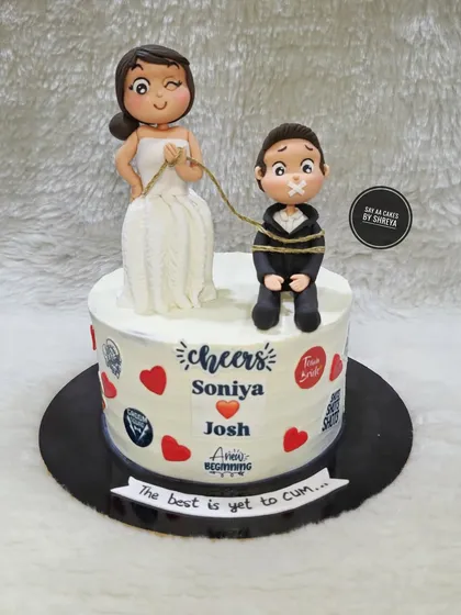A playful wedding cake that captures the fun side of marriage. The handmade bride and groom figurines show the bride playfully 'capturing' her groom, a humorous touch for a couple with a great sense of humor.