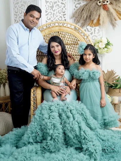 A regal family portrait. The mother sits on a wicker throne with her two children, creating a beautiful and composed image of this lovely family.