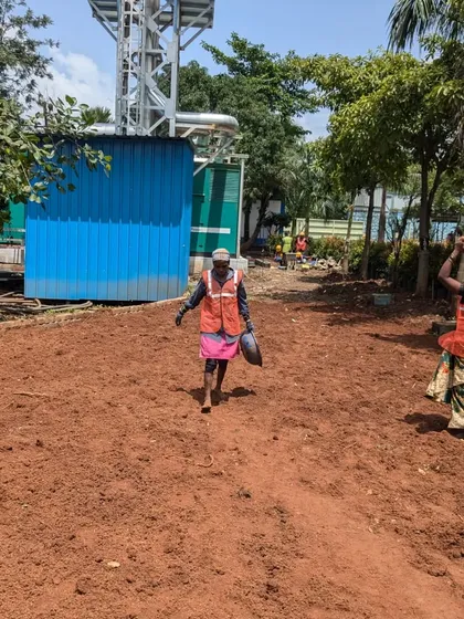 Our hardworking laborers carry soil across the site, a fundamental part of preparing the ground for planting.