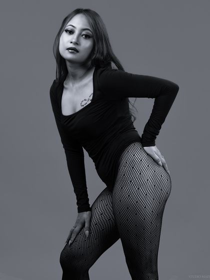 A strong, confident pose in black and white, highlighting the model's form.