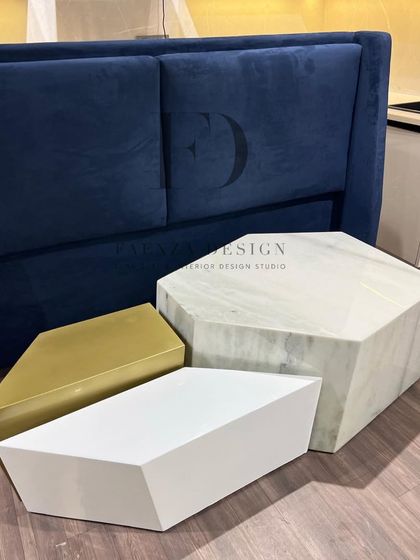 A collection of geometric nesting tables in different materials: white marble, polished gold metal, and matte white. These pieces can be arranged in various configurations to suit your needs.