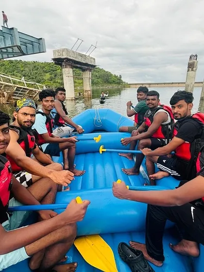 A team of rafters takes a photo break near a partially constructed bridge, an interesting landmark on their river journey.