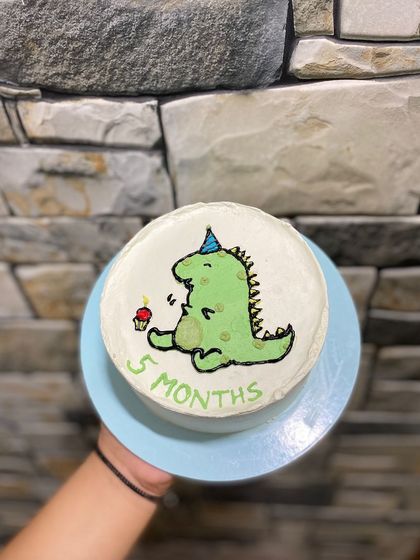The dinosaur cake against a cool backdrop, showing its simple and cute design.