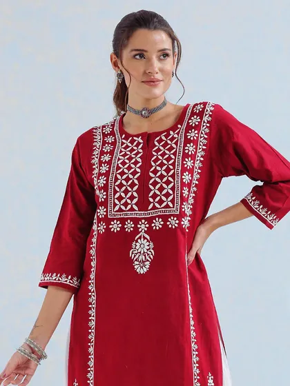 A close-up of a beautiful red kurta with intricate white embroidery. This is a great option for a bride who wants a pop of traditional color for one of her smaller wedding events.