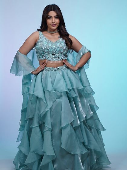 A full-length view of the sky-blue ruffled lehenga, showing how the layers create a beautiful, voluminous look perfect for a grand entrance.
