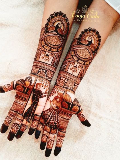 A full view of a gorgeous engagement design. The artwork includes dancing figures on the palms, set against an architectural backdrop, with large, elegant peacocks on the forearms.