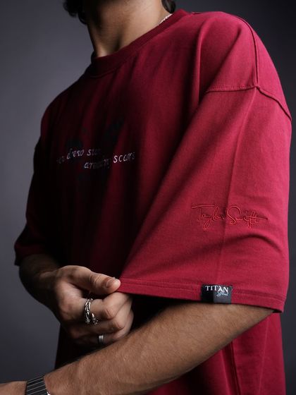 A detailed close-up of the sleeve and fabric of a burgundy graphic tee. This type of shot is essential for e-commerce, showing customers the quality and unique details of the garment.
