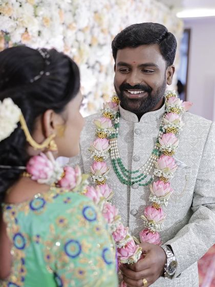 A candid shot of the couple during their engagement ceremony. The groom's admiration for his beautiful bride-to-be is clear.