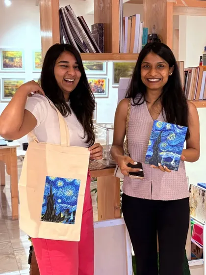 Nothing beats the joy of making something with your own hands. Here are two happy creators at our studio proudly showing off their finished 'Starry Night' canvas and a custom-painted tote bag.
