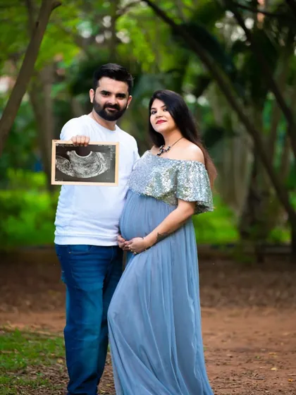 Sharing the first photo with the world. This couple holds their ultrasound picture in a beautiful outdoor park, a perfect way to announce their pregnancy.