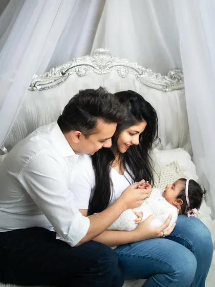 A fairy-tale setting for a new family. The elegant headboard and canopy create a dreamy backdrop for this intimate family portrait.