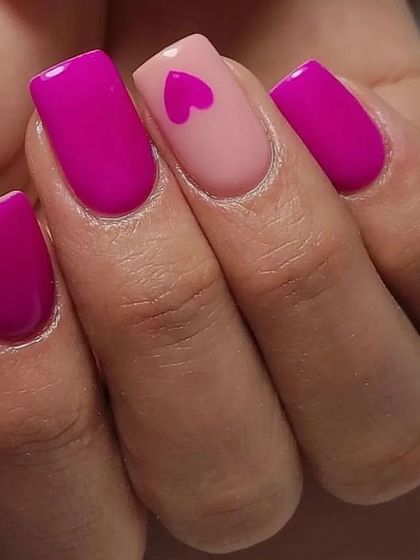 A bold and simple statement with a single heart accent nail. The vibrant magenta heart on a nude base stands out against the solid magenta nails.