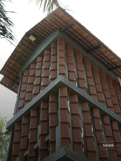 The unique facade of the staircase tower at the Manjunath Residence, made from stacked terracotta tiles, is a testament to innovative material use.