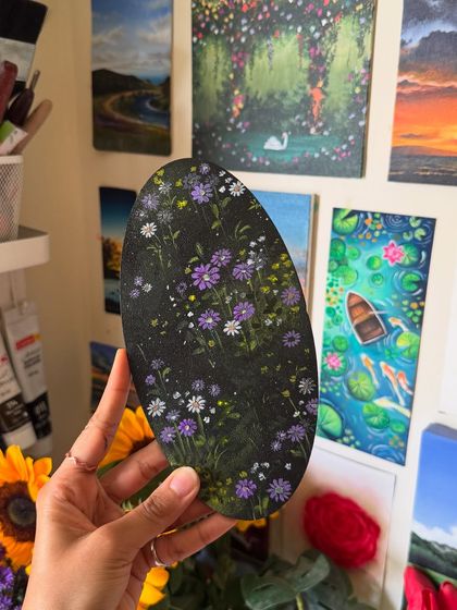The oval wildflower painting held up against my studio wall. This view shows how a uniquely shaped piece can add a special touch to a gallery wall.