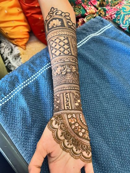 A close-up of the forearm, showing the detailed line work and shading in this bridal design.