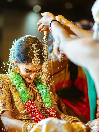 A serene moment as the bride is showered with rice, a symbol of prosperity and blessings.