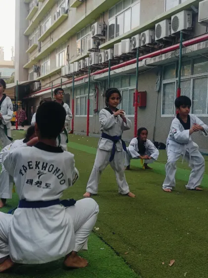 Students practice their horse-riding stance. This fundamental exercise, done together, builds a sense of unity and shared discipline.