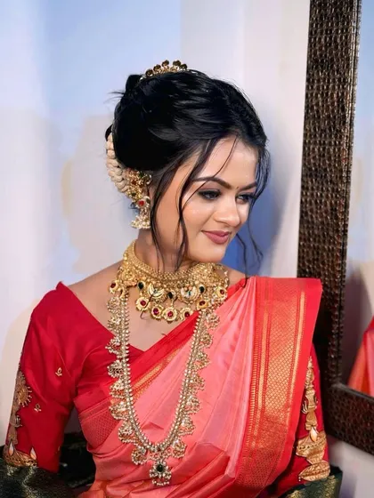 This shot highlights the beautiful hair and makeup from the side, showing the detailed work on the blouse and the elegant hair accessories.