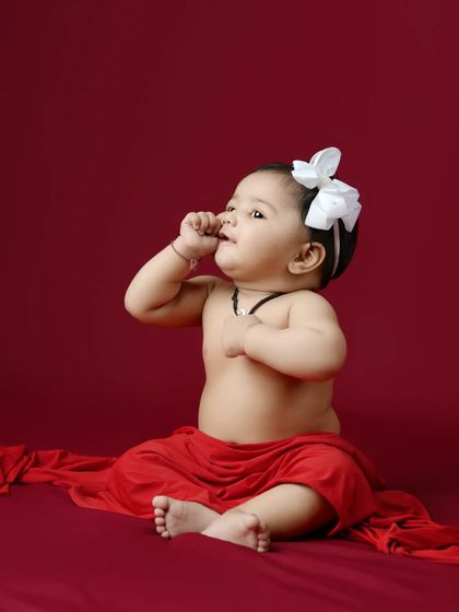 A similar pose from the same session, capturing a thoughtful moment as she looks up. These simple studio portraits are perfect for highlighting your baby's features.