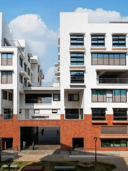A view of the central courtyard at the Srishti campus, where brick and white volumes frame an open, green space for students to gather and collaborate.