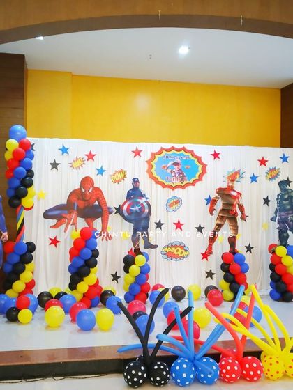 A full superhero squad theme for a 6th birthday. The stage features cutouts of Superman, Spiderman, Captain America, Iron Man, and Hulk against a starry backdrop.