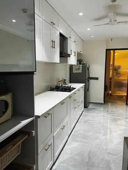 This angle shows the kitchen's appliance integration, with designated spots for the refrigerator and microwave. The consistent design of the cabinetry creates a cohesive and highly organized culinary workspace.
