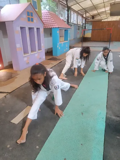 Students engage in deep lunges to stretch their leg muscles. This is a key exercise for developing the flexibility needed for powerful kicks.