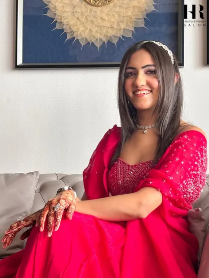 The complete look, ready for any celebration. Dressed in a vibrant outfit with beautiful henna, this client's party makeup ties everything together for a stunning, festive appearance.