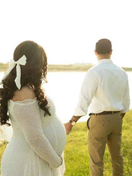 Looking towards the future together. This shot from behind shows the couple holding hands and gazing at the water, a symbol of the new life and journey ahead of them.
