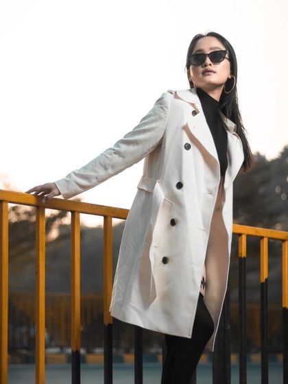 A confident pose against the railing, capturing the urban-chic aesthetic of the shoot.