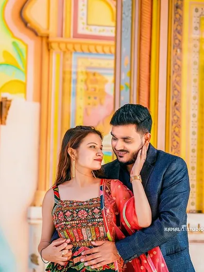 An intimate portrait framed by the colorful frescoes of a Rajasthani palace. The soft light and gentle embrace create a moment of pure romance.