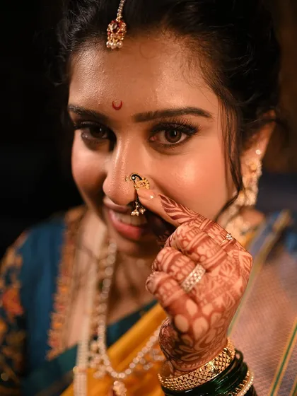 A close-up on the details. The intricate nath, the crescent bindi, and the softly defined eyes come together for a stunning Marathi bridal look.