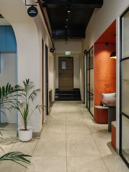 The main corridor at the Vision office is designed to be more than just a pathway. It features breakout nooks with bold colors, like this red-walled seating area, for informal chats or quiet work.