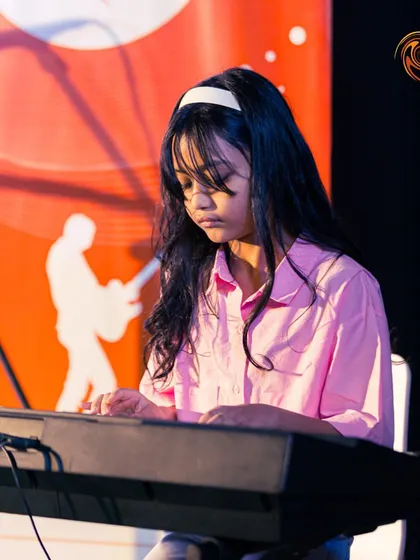 A young pianist in deep concentration during her performance at a Swirl Spotlight event.