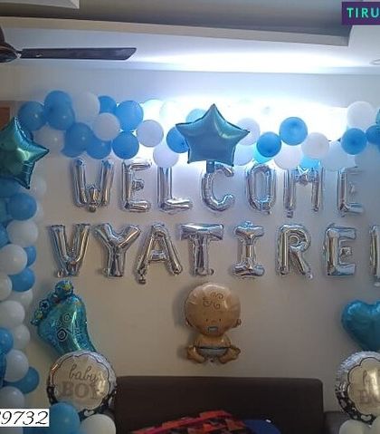 The full view of the 'Welcome Home' setup for baby Vyatirek, showing the balloon arrangements and foil letter display.