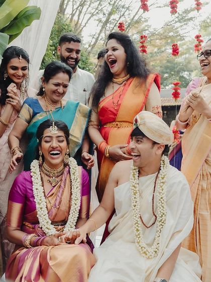 Pure, uninhibited laughter from the couple and their families during a fun wedding game, capturing the spirit of celebration.