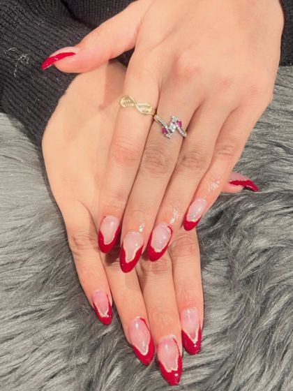 Bold and beautiful V-shaped French tips in a classic red. This design on almond nails is both elegant and powerful.