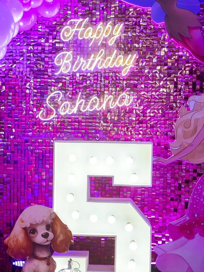 A close-up of the personalized neon sign and marquee number for the birthday girl's celebration.