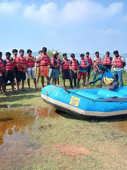 An instructor demonstrates the proper way to enter and position oneself in a raft during a basic aqua sports course.