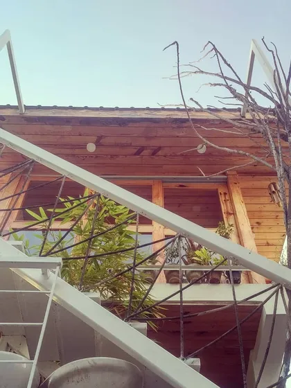Another view of the studio, looking up at the wooden cabin through the white metal staircase. It's a creative space designed to fuel creative work.