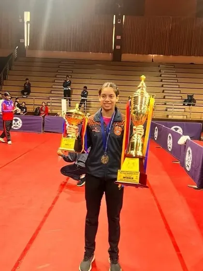 Ananya Chande looking triumphant with her Gold and Silver trophies from the School Games Federation of India (SGFI) games in Indore. Her success in both team and individual events highlights her versatility as a competitive table tennis player.